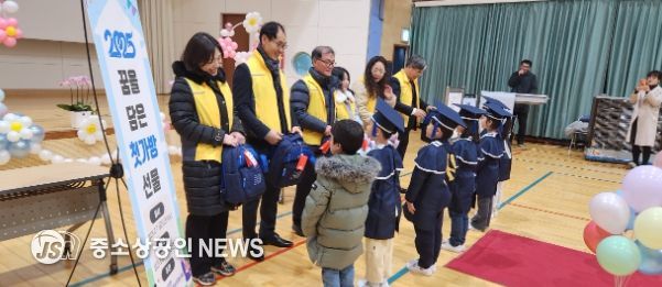 제103회 성전초등학교 졸업식에서 성전면지사협 위원들이 예비 신입생들에게 가방을 전달하고 있다.