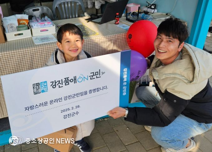 강진 청자축제장 부스에서 가입한 신규회원이 강진품애 온 군민증을 들고 있다.
