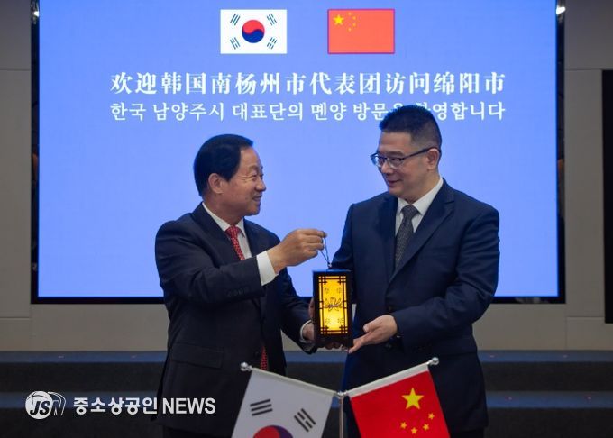 주광덕 남양주시장(좌)이 리원 몐양시장(우)에게 기념품을 전달하고 있다.