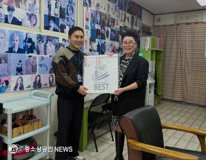 군 관계자가 공중위생서비스 평가 우수업소에 현판을 건네고 있다