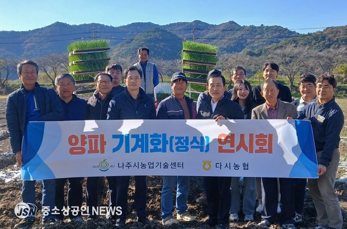 양파 기계 정식 연시회에 참가한 농업인들과 관계자들이 기념촬영을 하고 있다.