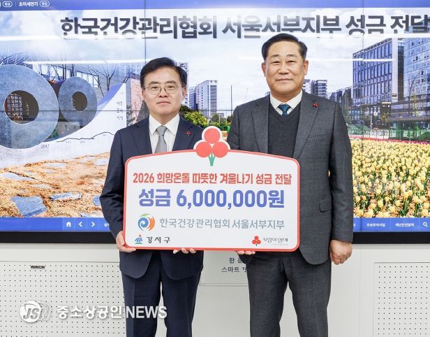 진교훈 서울 강서구청장(왼쪽)이 구청장실에서 열린 ‘한국건강관리협회 서울서부지부 이웃돕기 성금 전달식’에서 김민수 본부장으로부터 성금을 전달받고 기념촬영을 하고 있다.