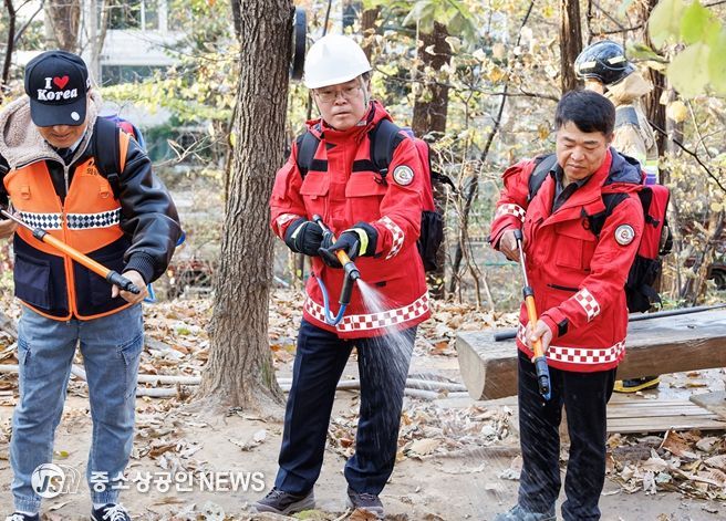 진교훈 서울 강서구청장(가운데)이 21일 오후 우장산 일대에서 열린 ‘유관기관 합동 산불진압훈련’에서 등짐펌프를 매고 산불진화대원과 함께 잔불진화작업을 하고 있다.