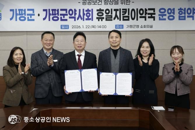 서태원 가평군수(사진 왼쪽에서 세번째)와 안병현 가평군약사회 회장(〃 네번째) 등이 22일 휴일지킴이약국 운영 협약식 후 협약서를 보이며 기념촬영을 하고 있다.