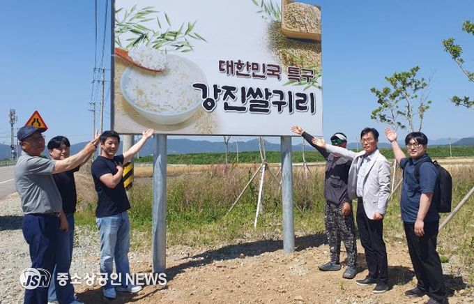 강진군 쌀귀리연구회 임원과 유통 관계자들이 쌀귀리 홍보 간판앞에서 기념촬영을 하고 있다.